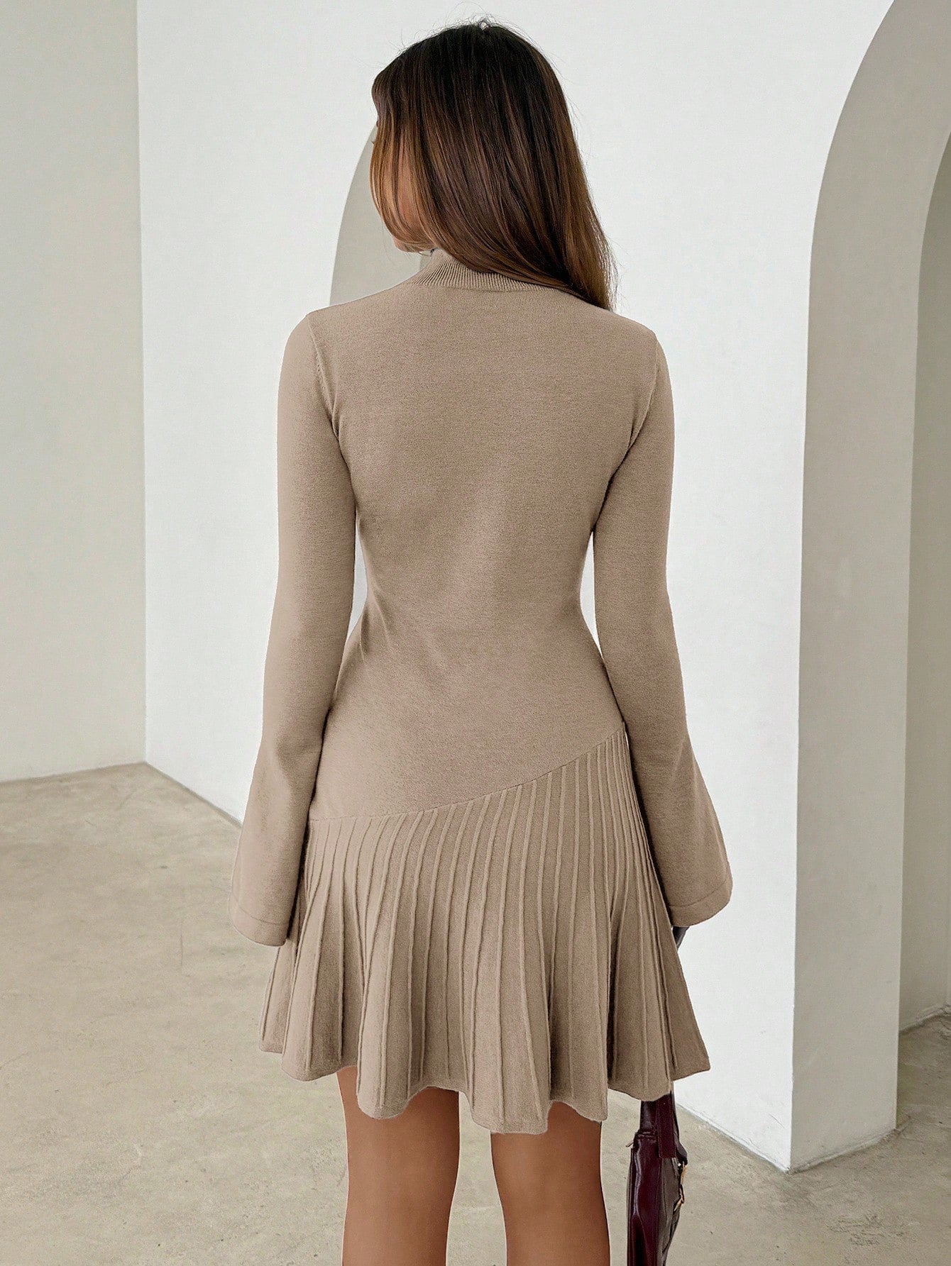 Woman wearing long turtleneck knitted dress facing forward