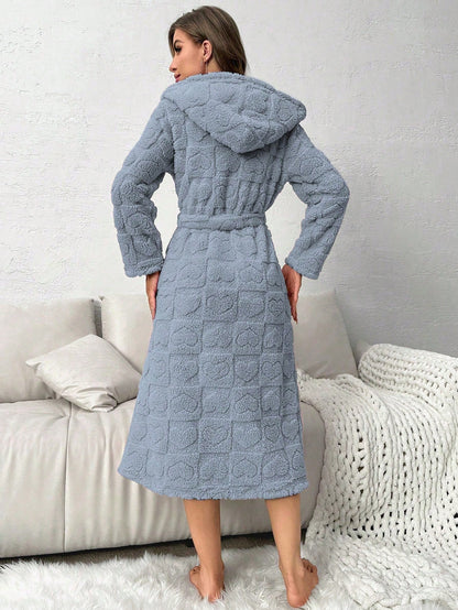 Woman wearing a textured blue robe standing in a living room.