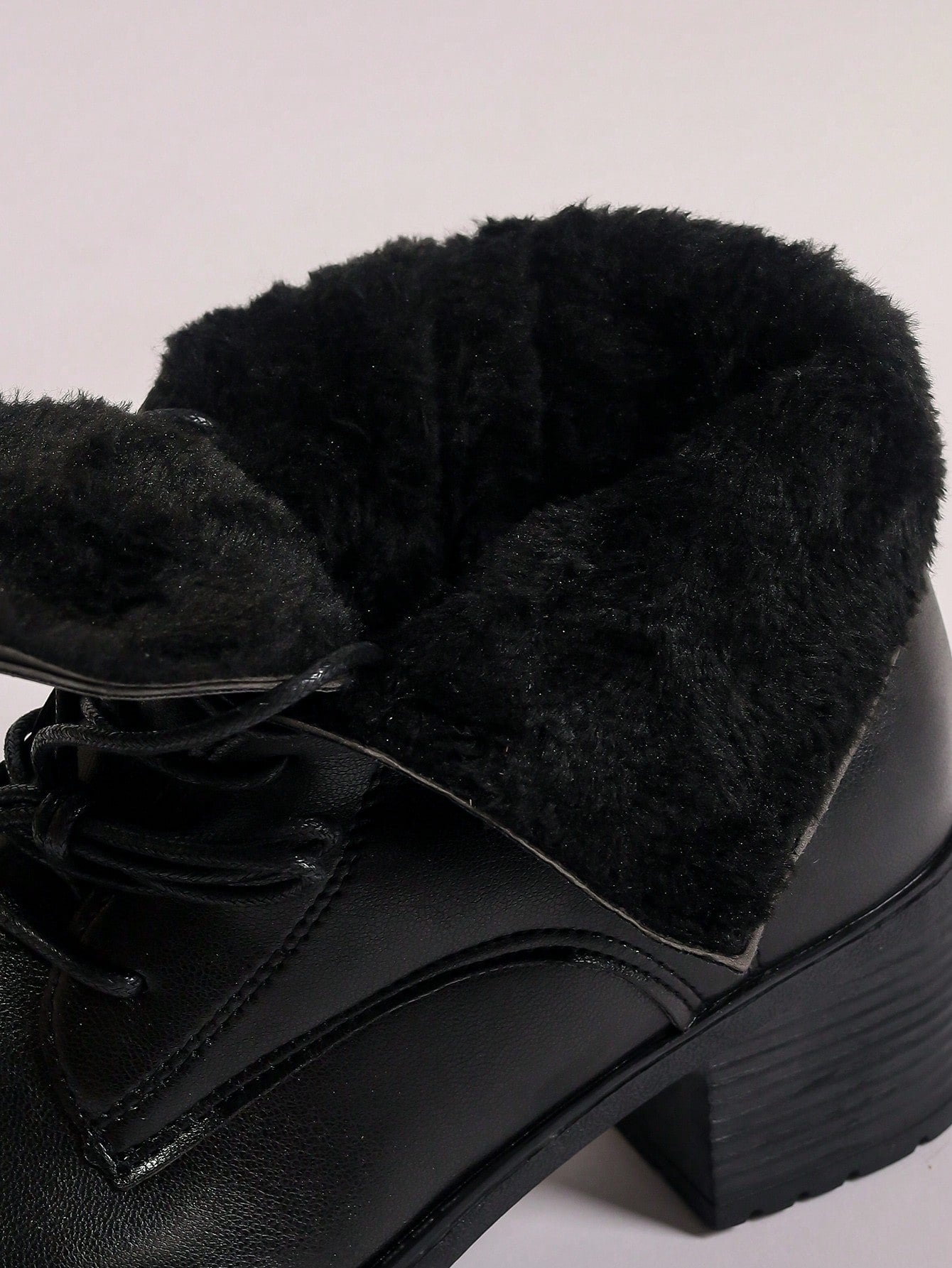 Black leather boot with plush lining on a light gray background Nushes 