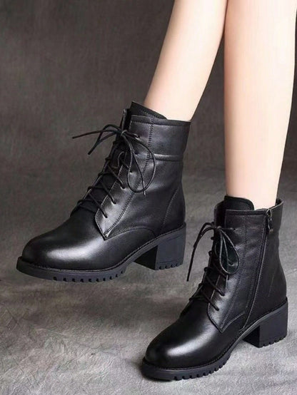 Black leather boots with laces on a gray background Nushes 