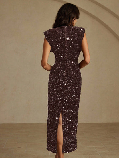 Woman wearing a dark sequin dress with a high slit on a beige background