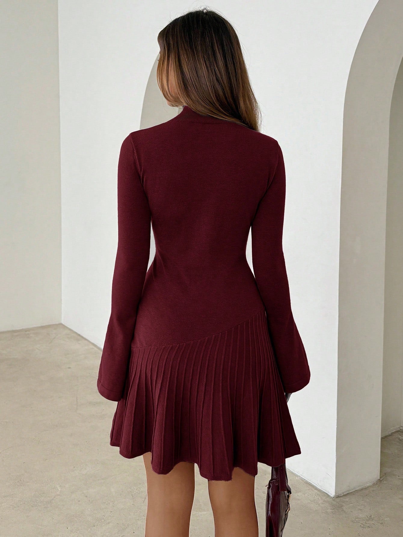 Woman wearing long turtleneck knitted dress facing forward