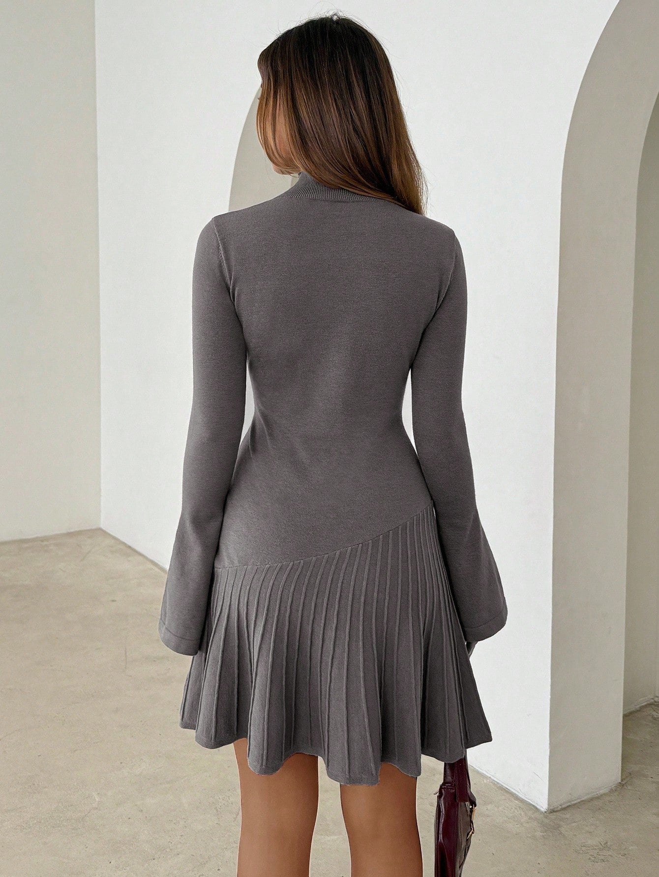 Woman wearing long turtleneck knitted dress facing forward